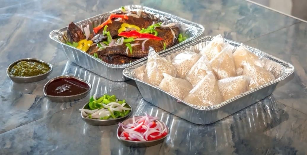 Banku with fresh juicy tilapia and vegetables with sauces
